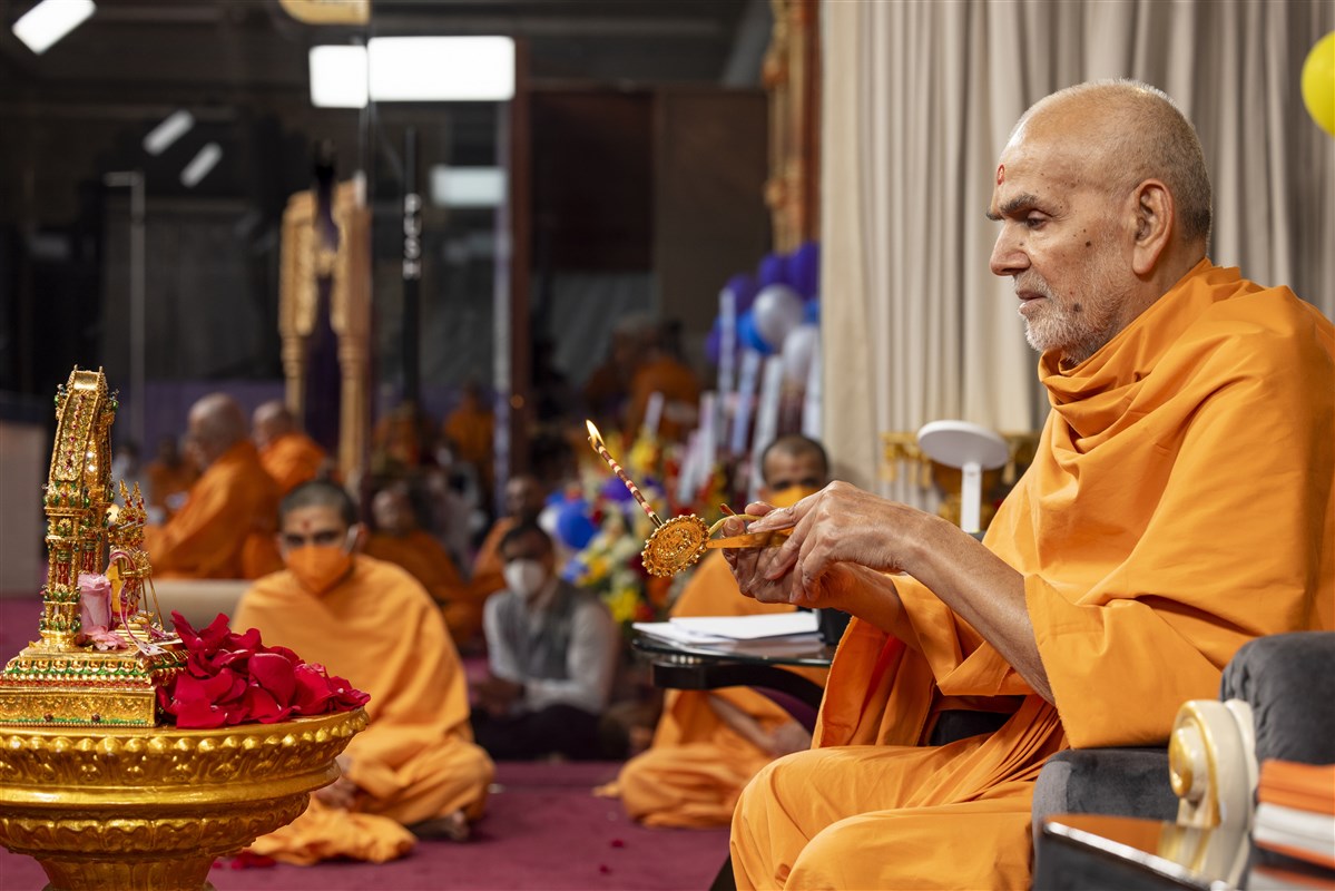 Swamishri performs the evening arti <br> For more information and photos of the event, please <a href='https://www.baps.org/News/2023/Mahant-Swami-Maharajs-90th-Birthday-Celebration-24062.aspx' target='blank' style='text-decoration:underline; color:blue;' >click here</a>