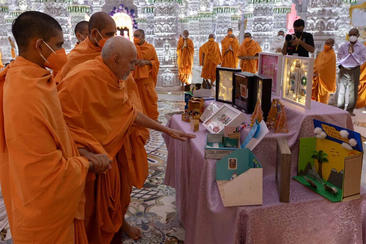 Swamishri observes the cards and swings crafted by the children