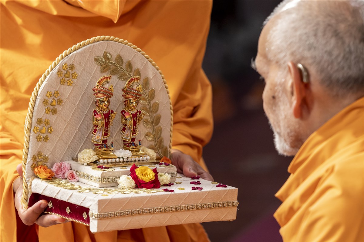 Swamishri deeply engrossed in the darshan of Shri Harikrishna Maharaj and Shri Gunatitanand Swami Maharaj