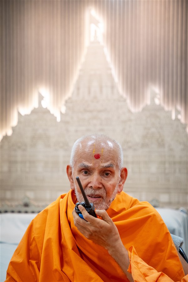 One-of-a-kind image of Swamishri conversing via a walkie-talkie