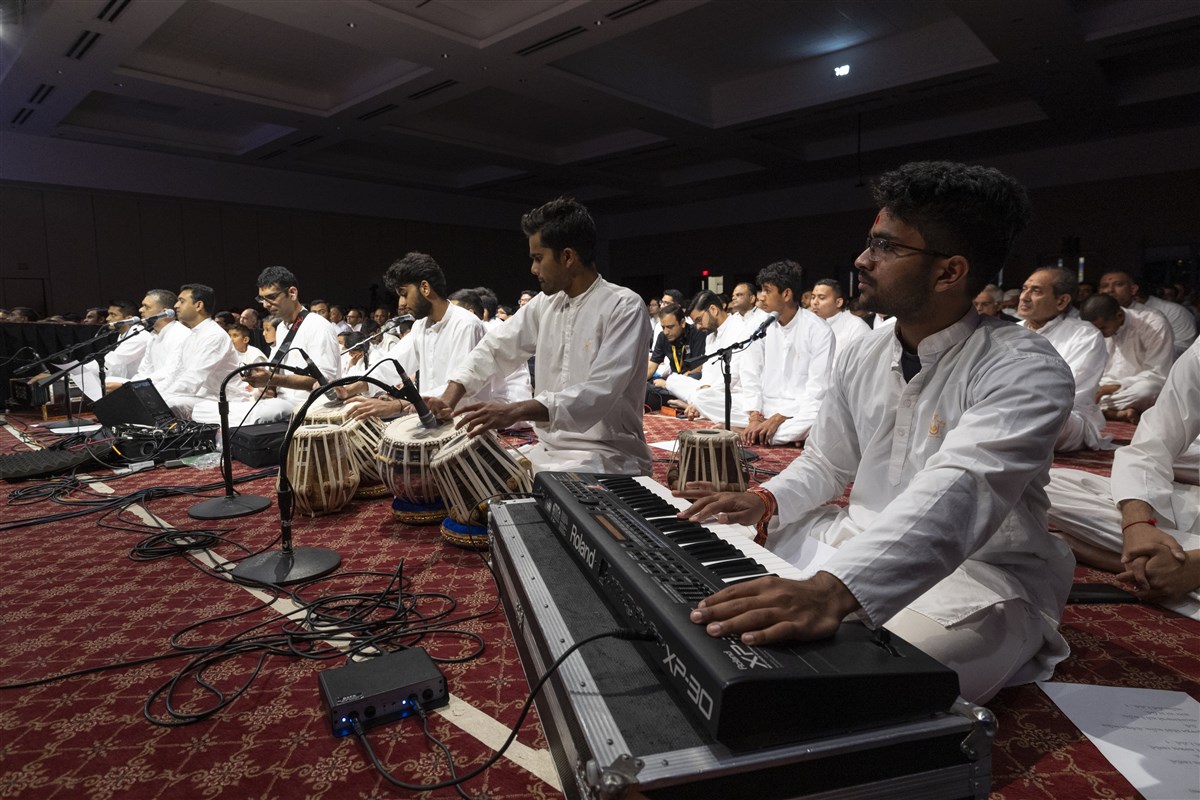 Youths offer kirtan bhakti during Swamishri’s puja