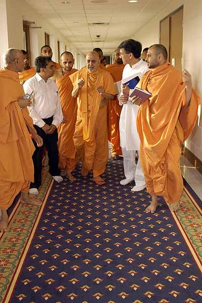 Kishori Din, July 13, 2004 - Swamishri answers a devotee's question on his way to pooja 