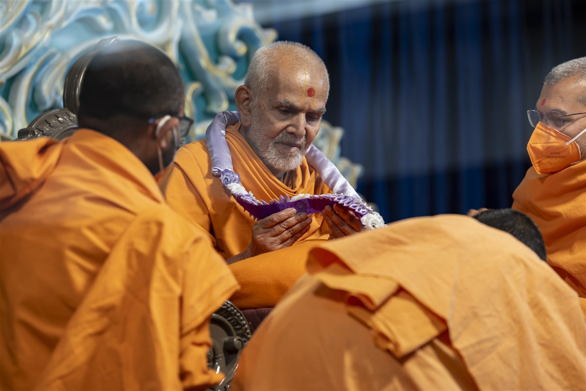 Swamishri observes the garland prepared with profound devotion