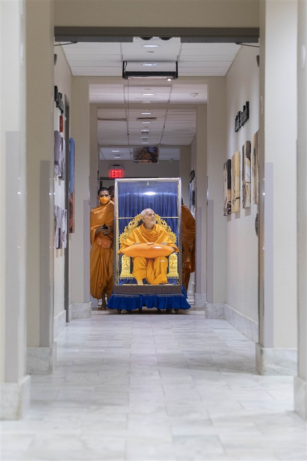 Swamishri gazes at one of the photos of Yogiji Maharaj as he makes his way to his residence