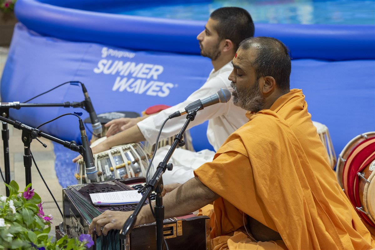 Swamis sing Jal Jhilani celebration arti while Swamishri performs his puja