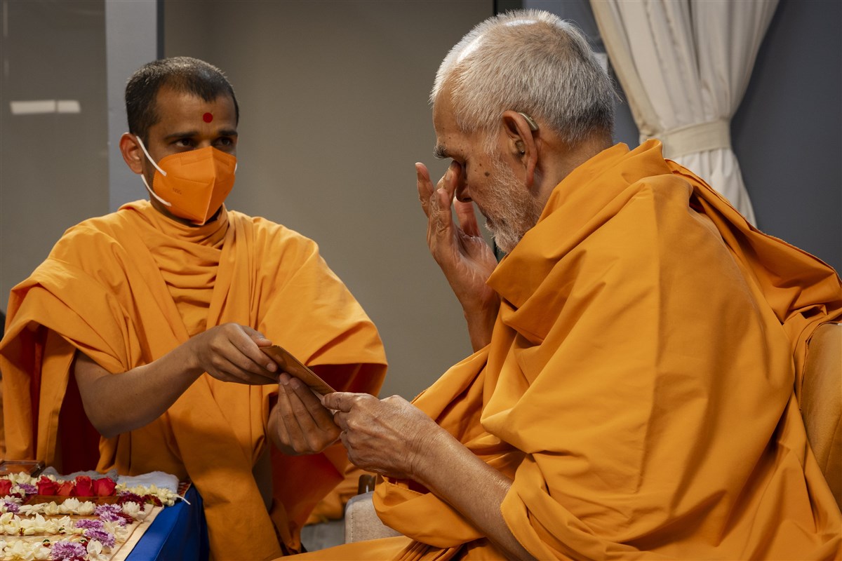 Swamishri touches his eyes after touching the feet of Shri Akshar Purushottam Maharaj