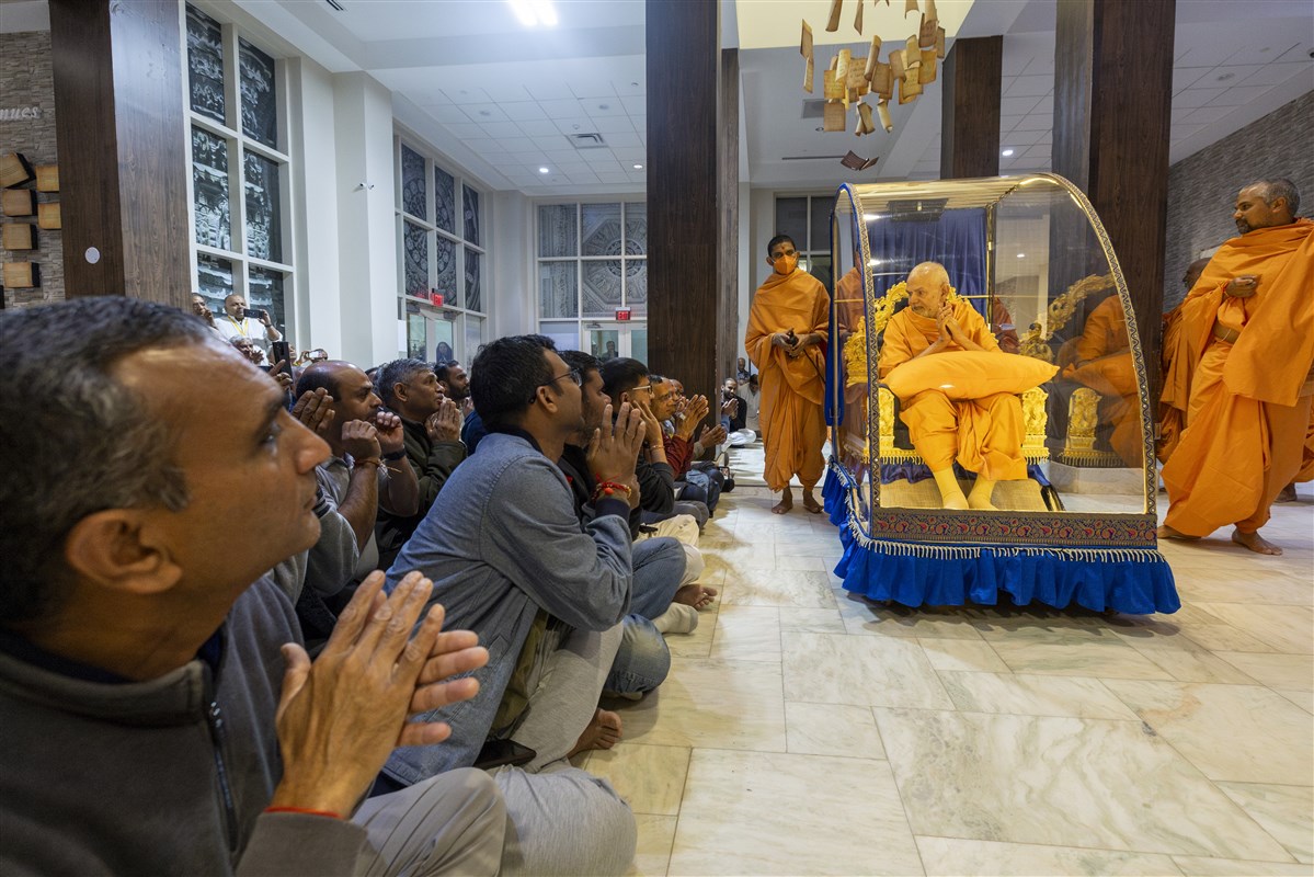 Swamishri greets devotees with folded hands