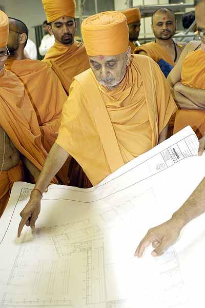 Balika Din, July 16, 2004 -  Swamishri studies the architectural plans for BAPS