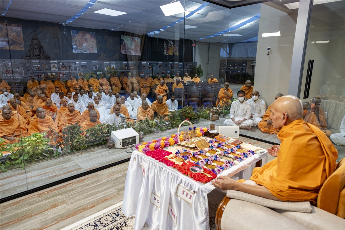 Swamishri meditates while swamis sing devotional songs