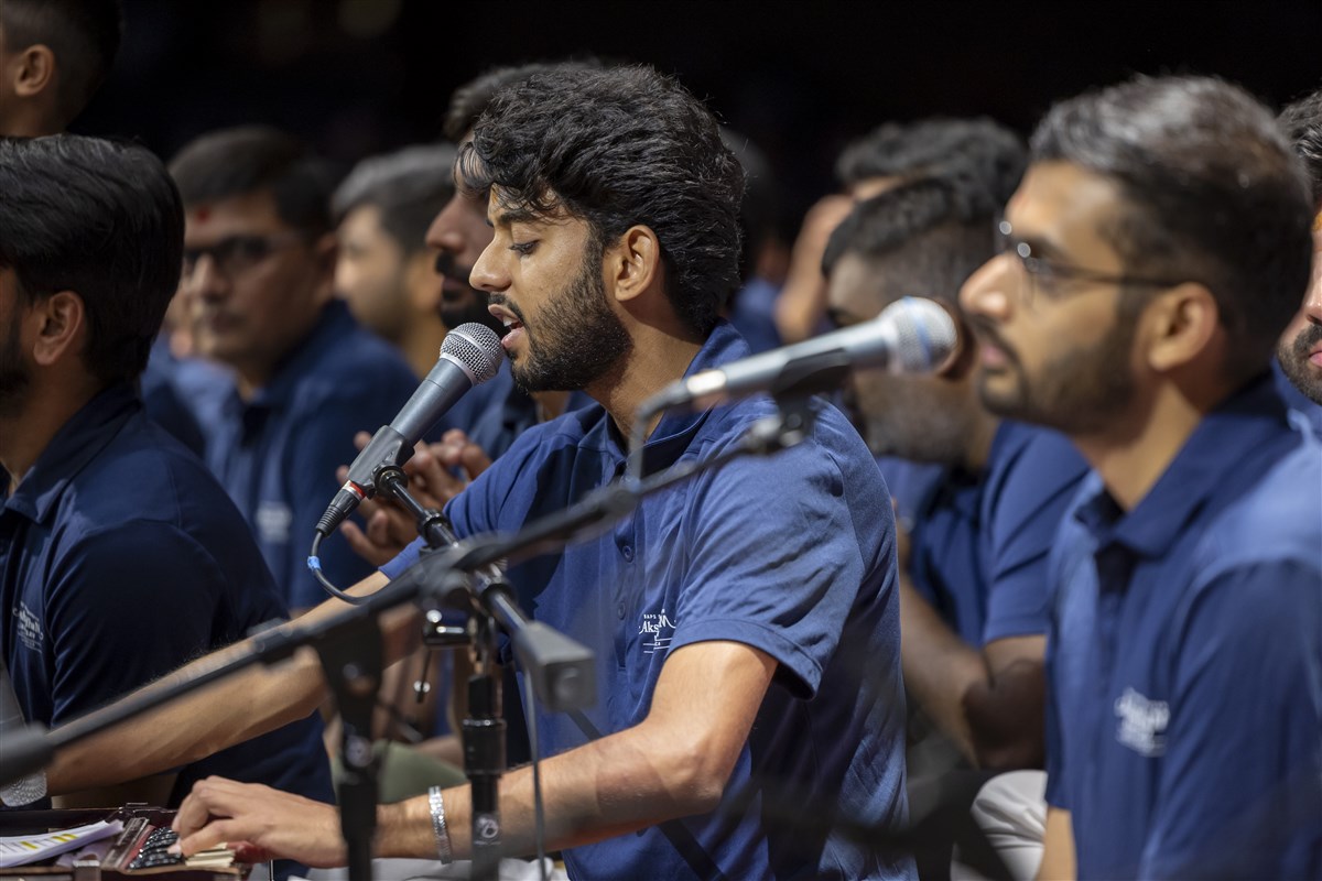 Volunteers sing kirtans while Swamishri performs his puja