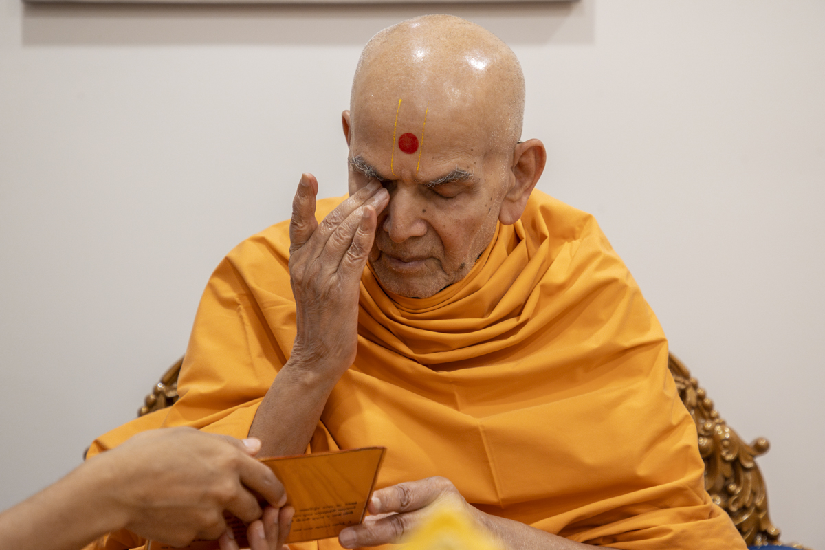 Swamishri touches his eyes after touching the feet of Shri Akshar Purushottam Maharaj