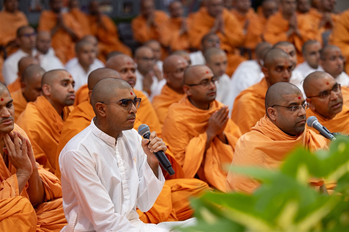 A sadhak leads everyone in reciting the sadhana mantra and daily prayer in Swamishri's puja