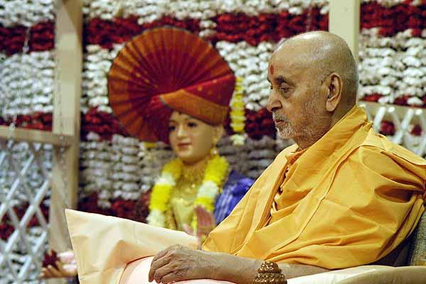 Swamishri performs mala during his morning puja on the day of the Murti Pratishtha 