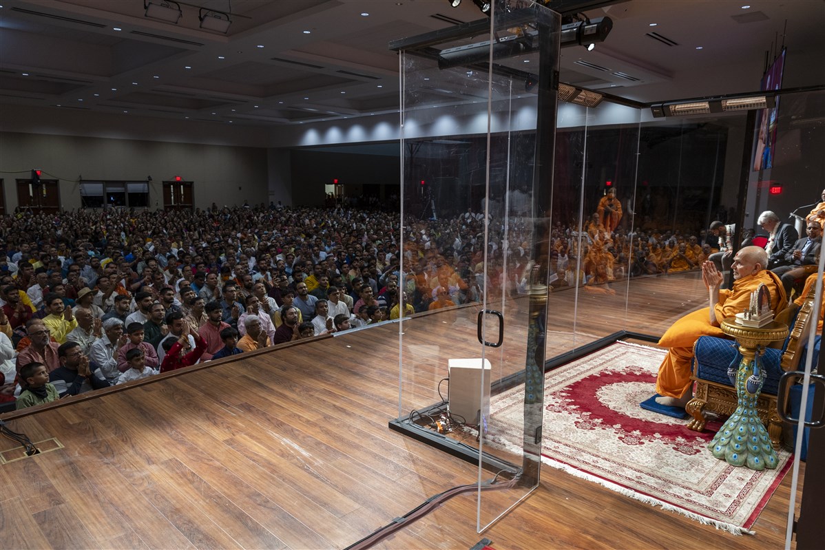 Devotees greet Swamishri with folded hands