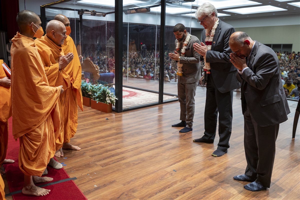 Swamishri greets invited guests with folded hands