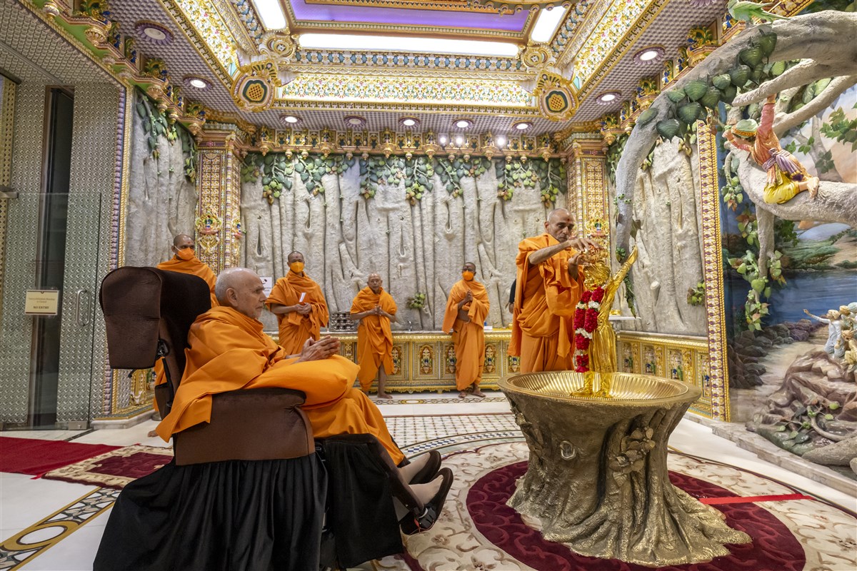 Swamishri engrossed in darshan while Pujya Anandswarupdas Swami performs the abhishek of Shri Ghanshyam Maharaj