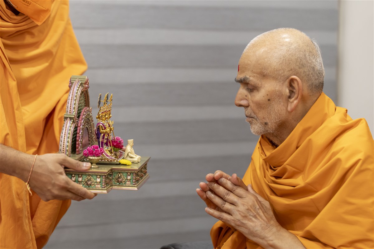 Swamishri engrossed in the darshan of Shri Harikrishna Maharaj and Shri Gunatitanand Swami Maharaj