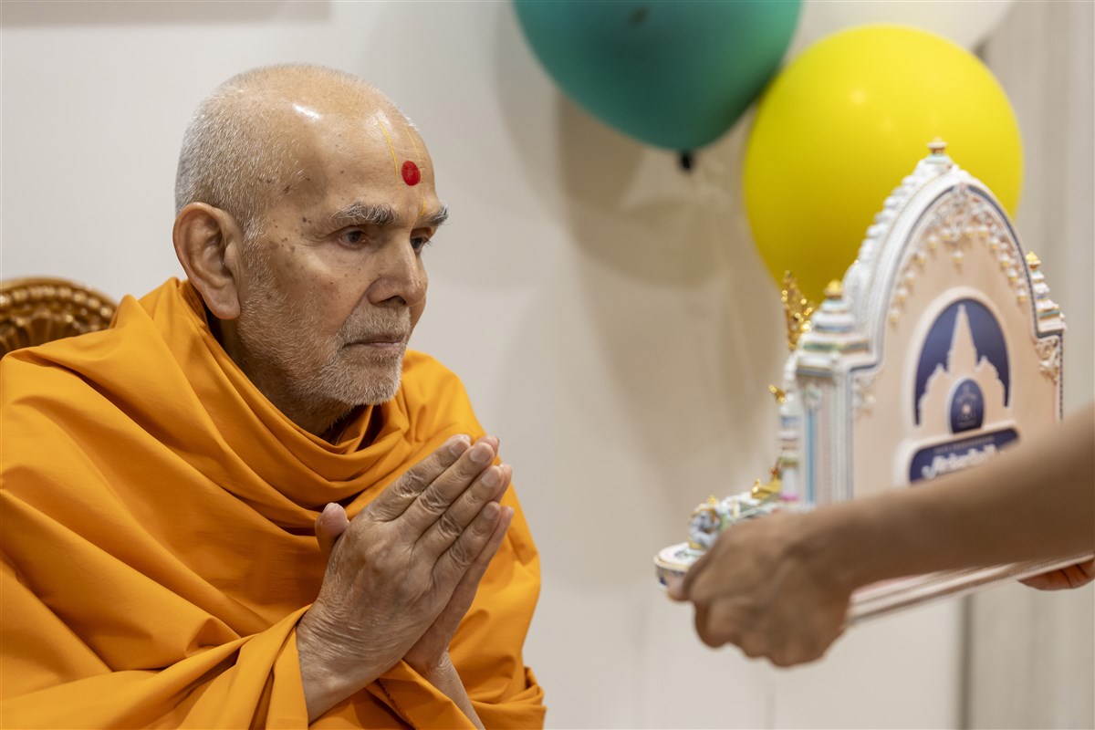 Param Pujya Mahant Swami Maharaj deeply engrossed in the darshan of Shri Harikrishna Maharaj and Shri Gunatitanand Swami Maharaj