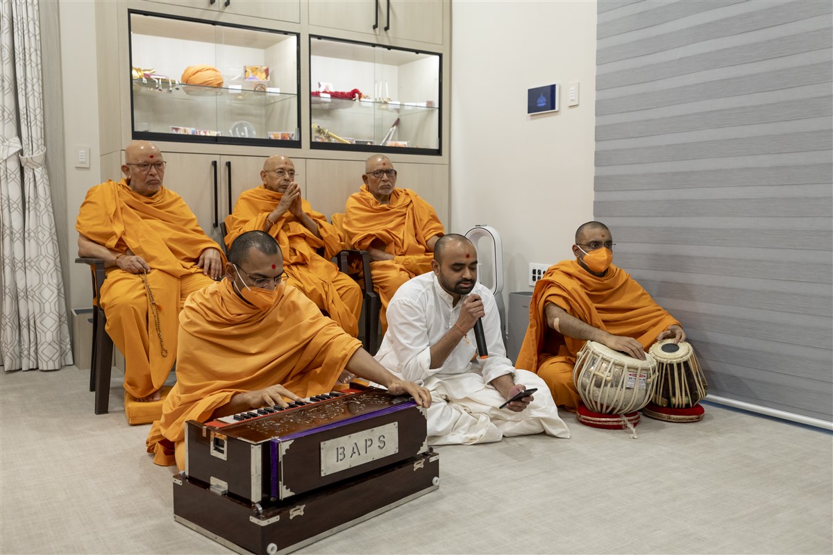 A sadhak sings a kirtan in Swamishri's puja