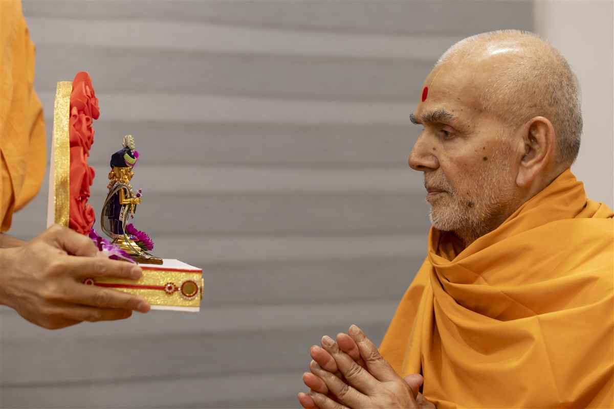 Swamishri deeply engrossed in the darshan of Shri Harikrishna Maharaj and Shri Gunatitanand Swami Maharaj
