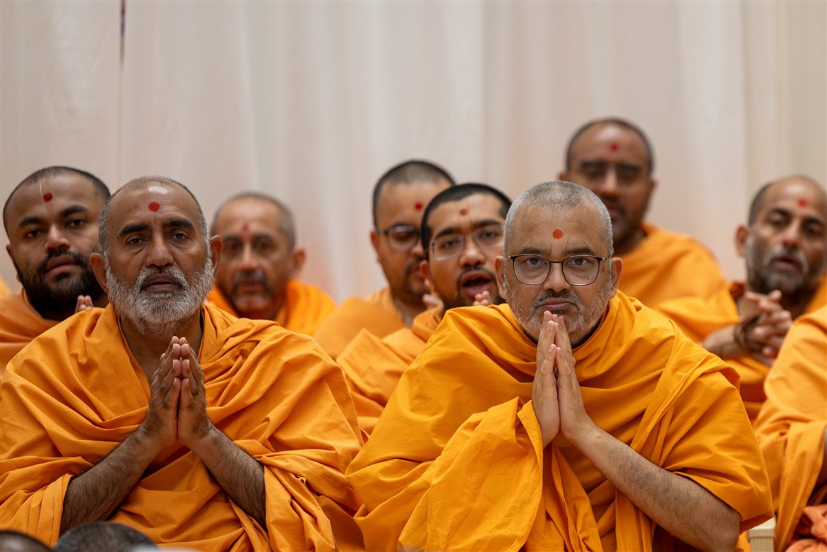 Swamis engrossed in Swamishri's puja