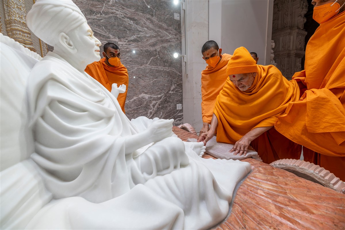 Swamishri touches the feet of Brahmaswarup Yogiji Maharaj