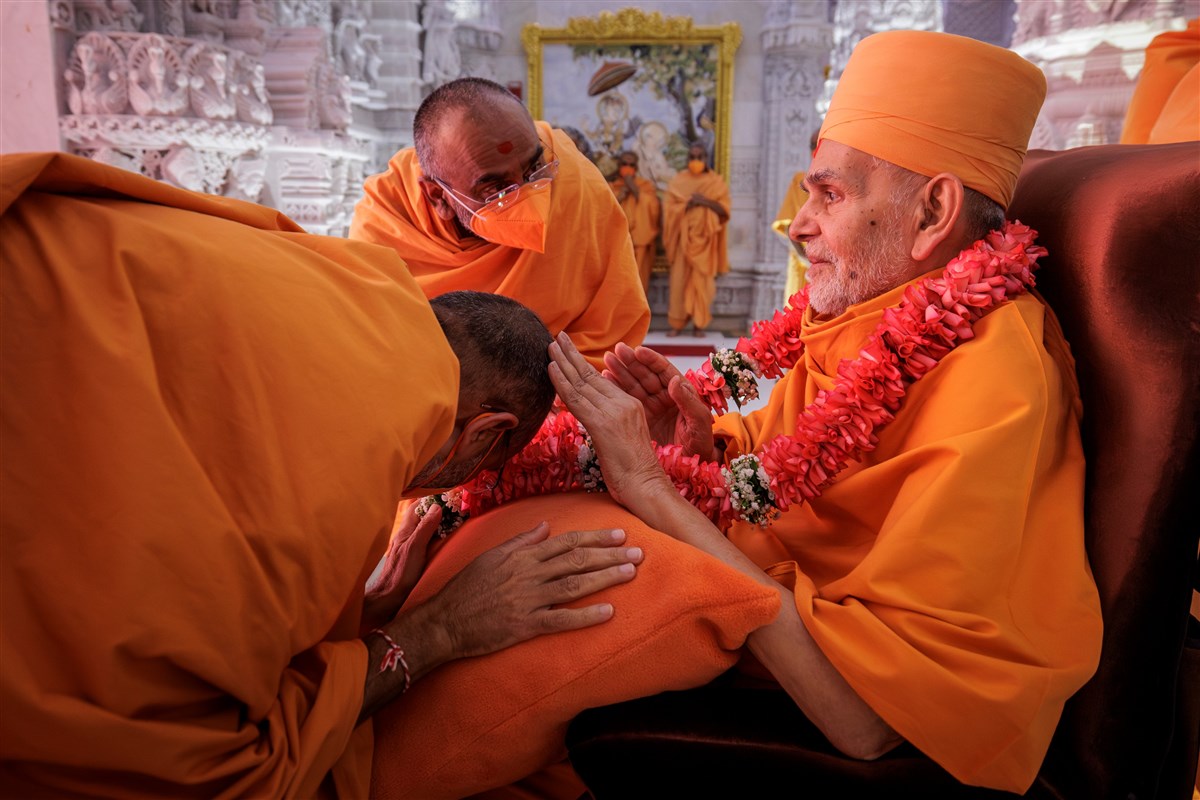 Swamishri blesses swamis after they garland him