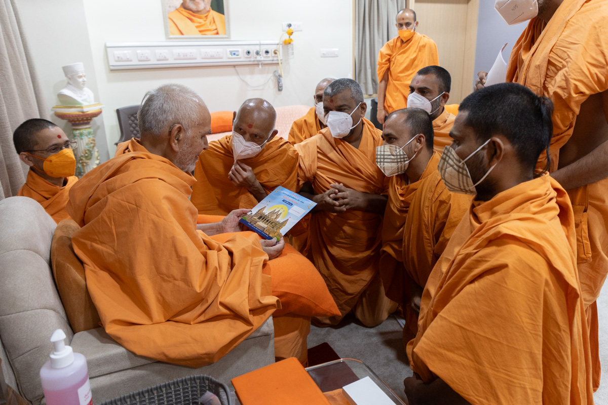 Sadhus from Nadiad present an invitation card for the inauguration of the new BAPS Shri Swaminarayan Mandir, Nadiad, to Swamishri