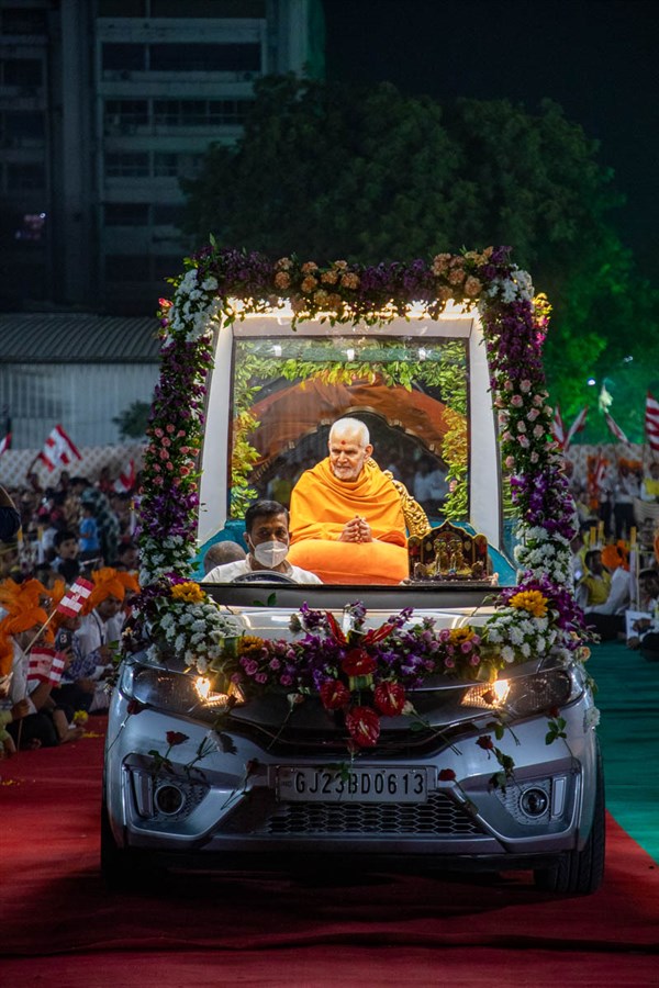 Swamishri greets all with folded hands as he passes through the assembly