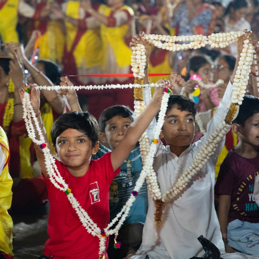 Children honor Swamishri with garlands