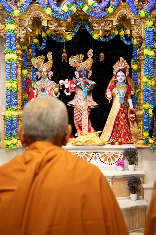 Swamishri engrossed in darshan of Shri Harikrishna Maharaj and Shri Radha-Krishna Bhagwan