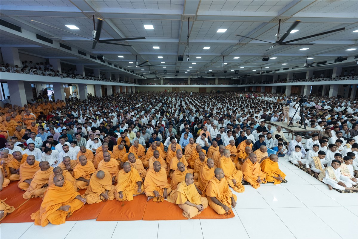 Sadhus and devotees engrossed in Swamishri's puja darshan