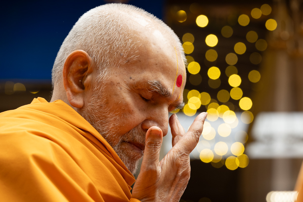 Swamishri touches his eyes after touching the feet of Shri Akshar-Purushottam Maharaj