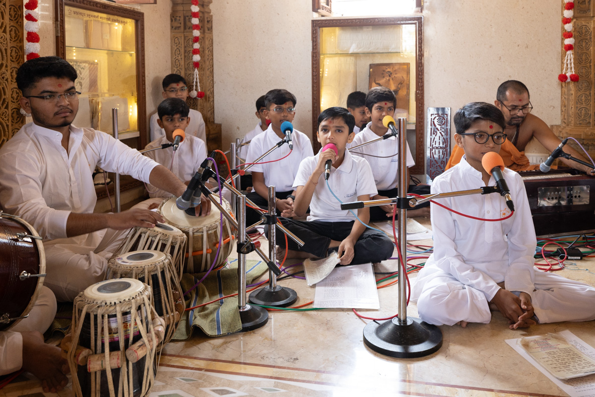 Students of Swaminarayan Vidyamandir, Gondal, sing thals to offer the annakut to Thakorji