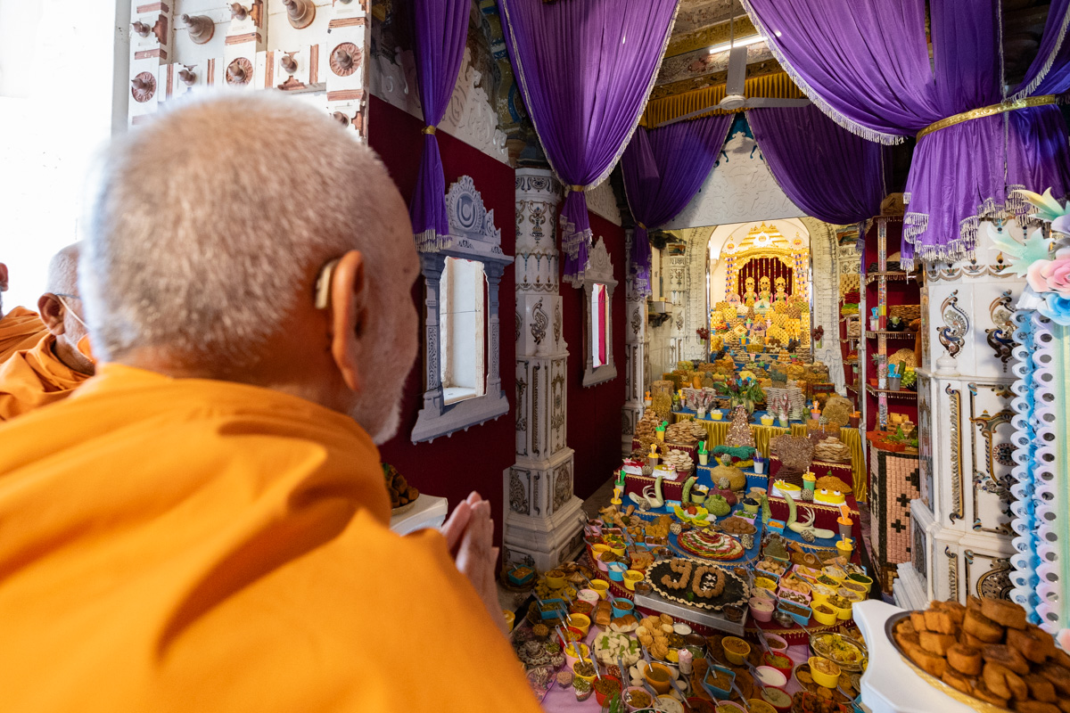 Swamishri doing darshan of annakut offered to Bhagwan Swaminarayan, Aksharbrahma Gunatitanand Swami and Shri Gopalanand Swami