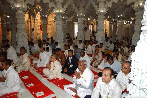 Devotees participate in the mahapuja vidhi for the murti prathistha