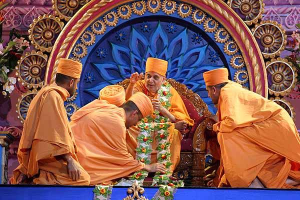 Midwest region saints offer Swamishri a garland 