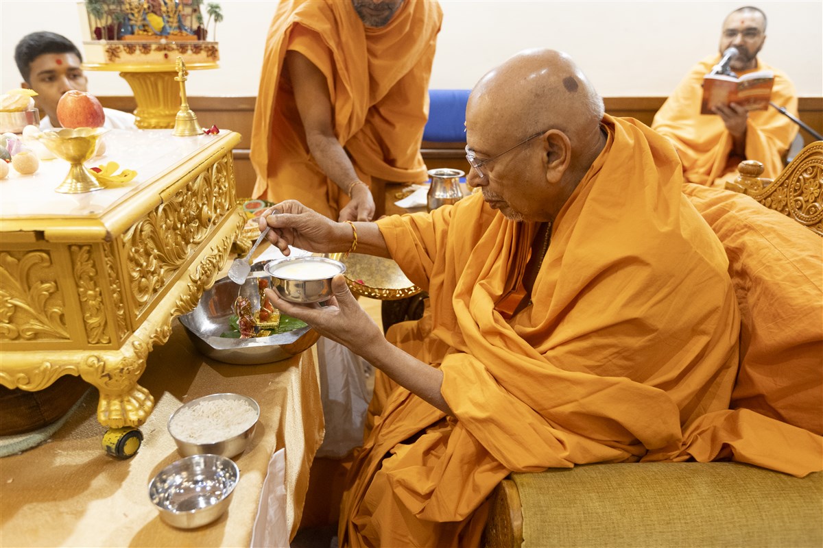 Tyagvallabhdas Swami bathed the murtis of Akshar-Purushottam Maharaj with panchamrut as part of the mahapuja ceremony