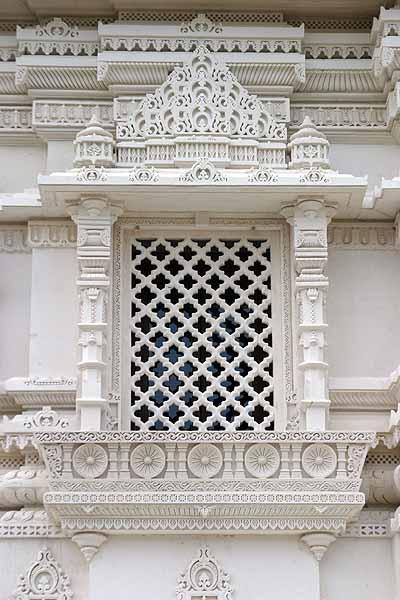 A beautiful window sits on the side of the Mandir 