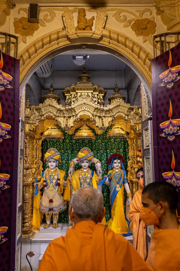 Swamishri engrossed in darshan of Shri Harikrishna Maharaj and Shri Lakshmi-Narayan Bhagwan