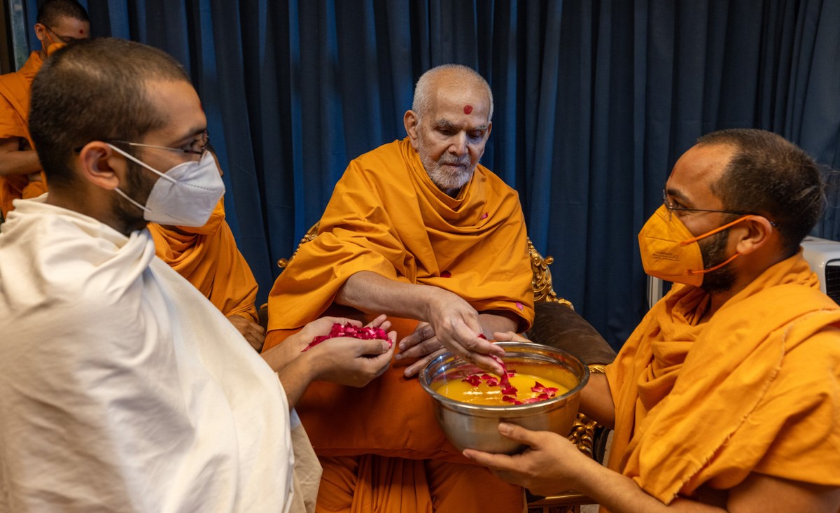 Swamishri sanctifies juice by showering flower petals