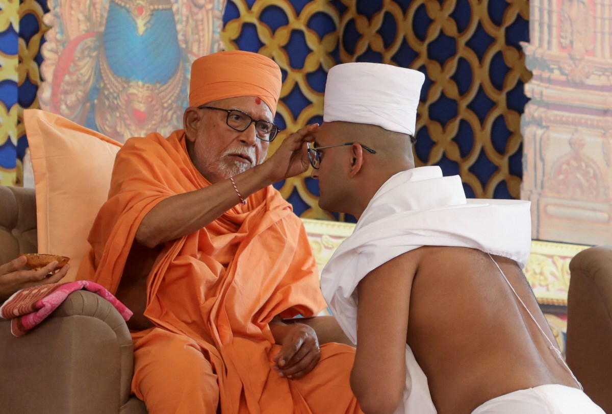 Pujya Bhaktipriya Swami (Kothari Swami) applies a chandlo to newly initiated parshad
