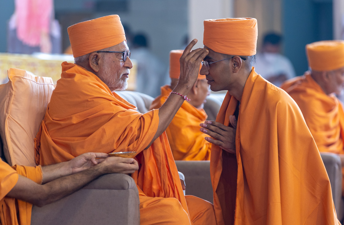 Pujya Bhaktipriya Swami (Kothari Swami) applies chandan archa to a newly initiated swami