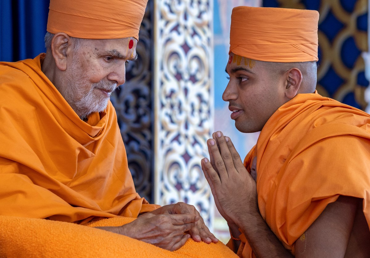Swamishri gives diksha mantra and blessings to a newly initiated swami