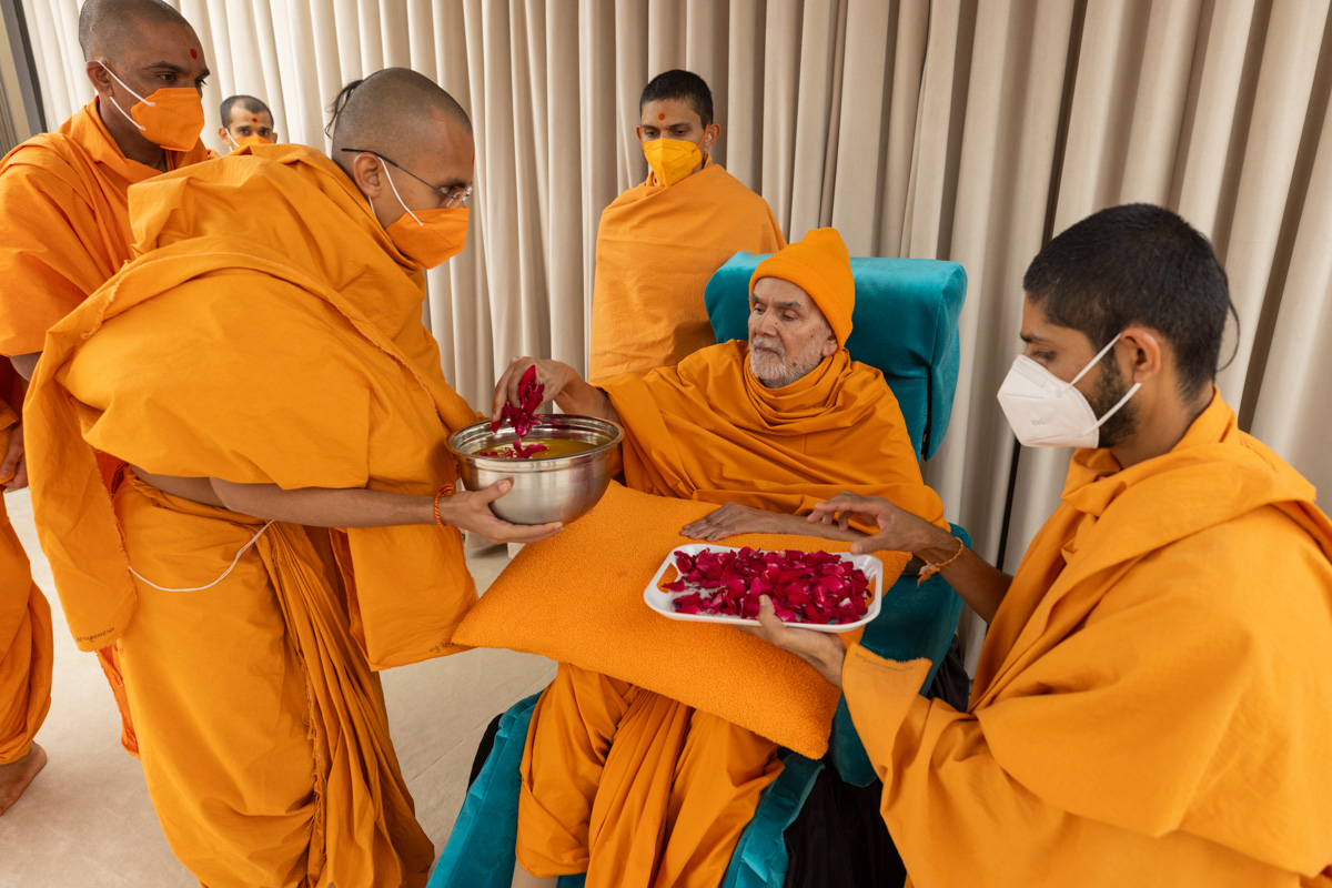 Param Pujya Mahant Swami Maharaj sanctifies juice by showering flower petals