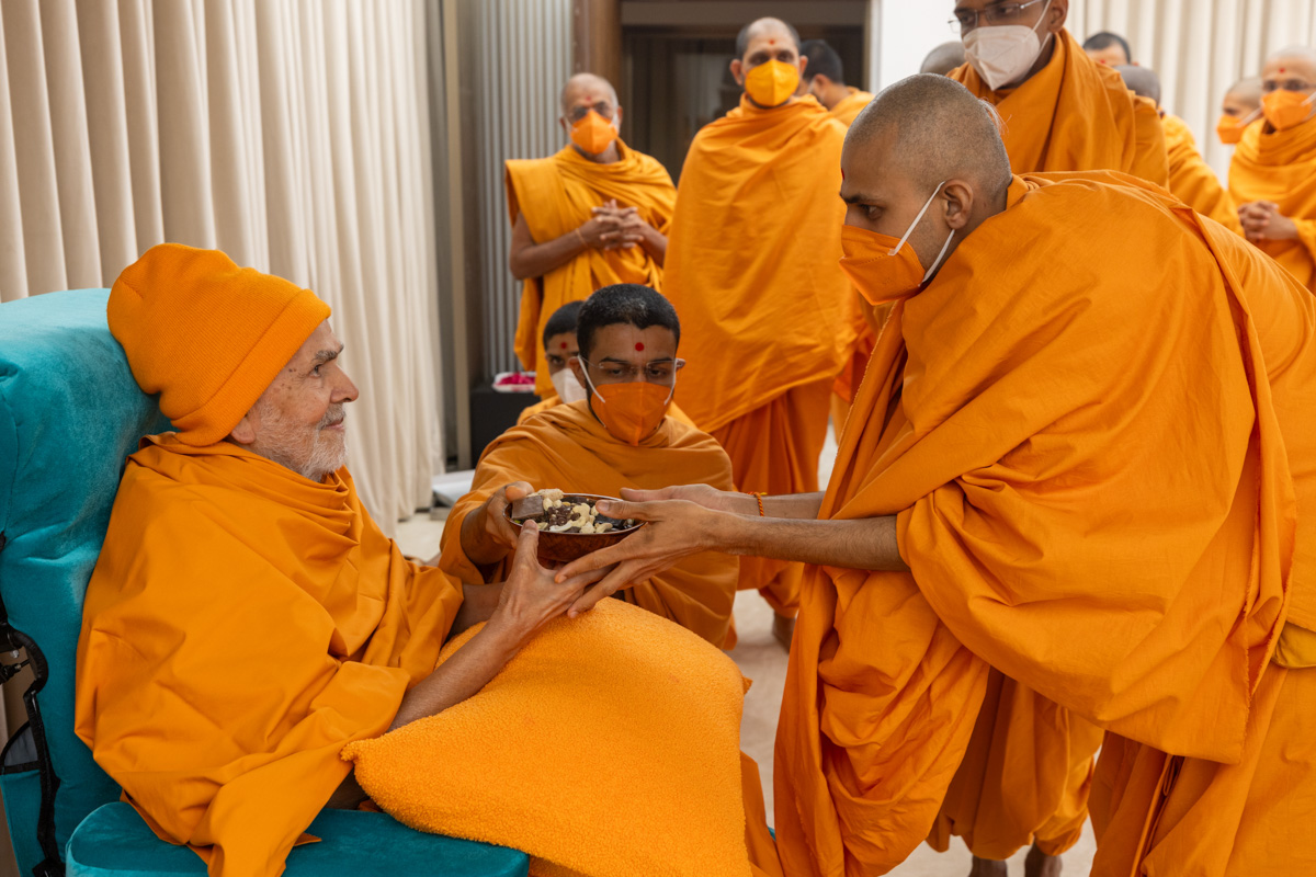 Swamishri gives prasad to newly initiated swamis