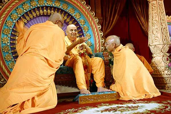  Swamishri is honored with a garland on Guru Bhakti Din 