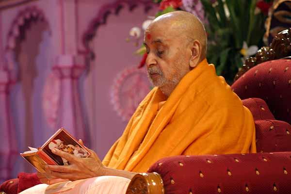 Swamishri reads the Shikshapatri during his morning puja 