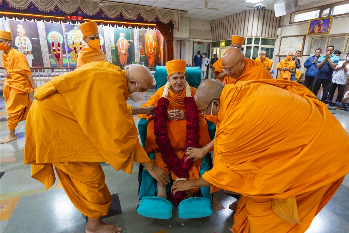 Swamis honor Swamishri with a garland as he departs from Bochasan in the afternoon