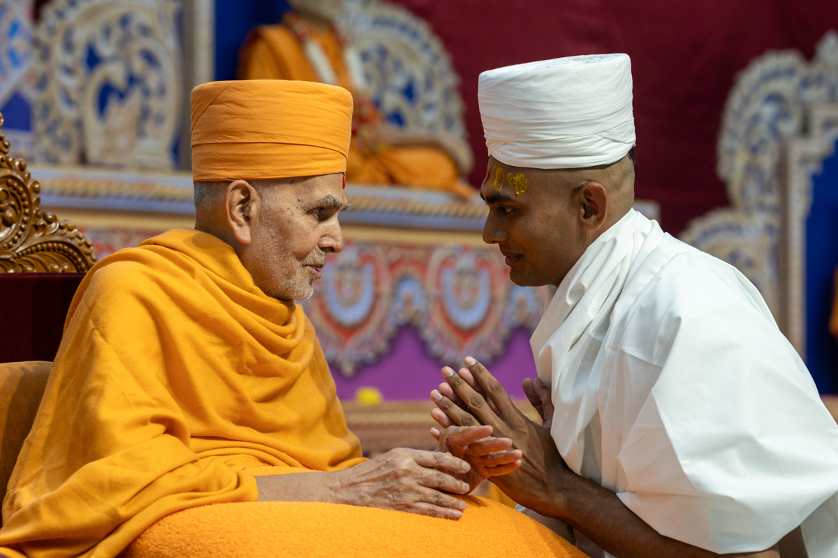 Swamishri gives diksha mantra and blessings to a newly initiated parshad